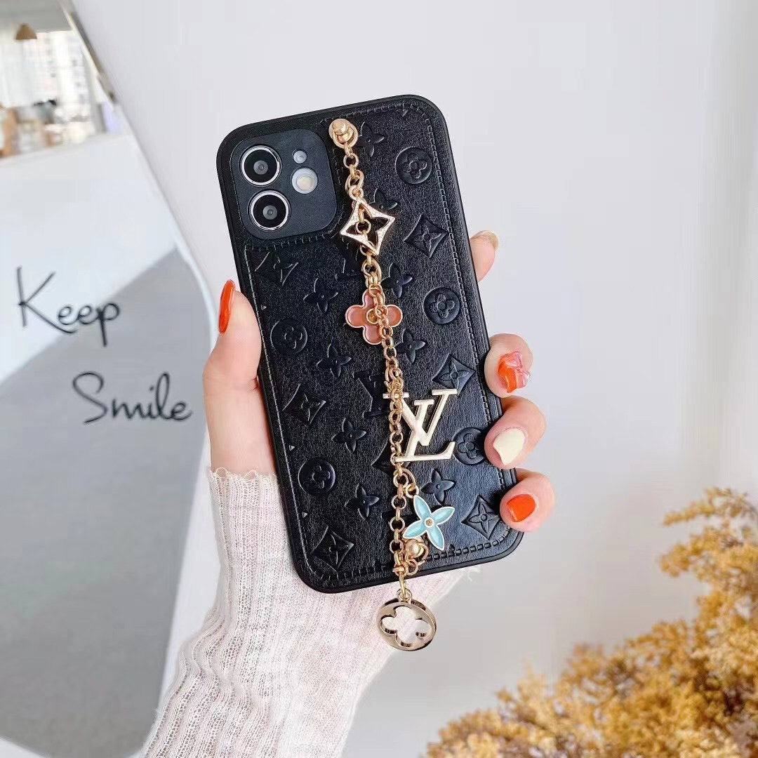 Black LV ornament iPhone case showing the decorative wrist strap and chain detail