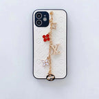 White LV ornament iPhone case showing the complete leather cover and decorative chain detail
